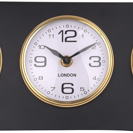 Close-up of the London dial on the Libra Interiors Matt Black Three Dial Mantel Clock, showing a white face with black numerals inside a gold bezel.