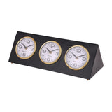 Libra Interiors Matt Black Three Dial Mantel Clock with Hong Kong, London and New York dials in gold bezels on a steel triangular frame with gold feet.