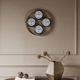 Libra Interiors Brushed Brass 4-Dial World City Wall Clock with London, New York, Hong Kong and Sydney faces, mounted on a neutral panelled wall.