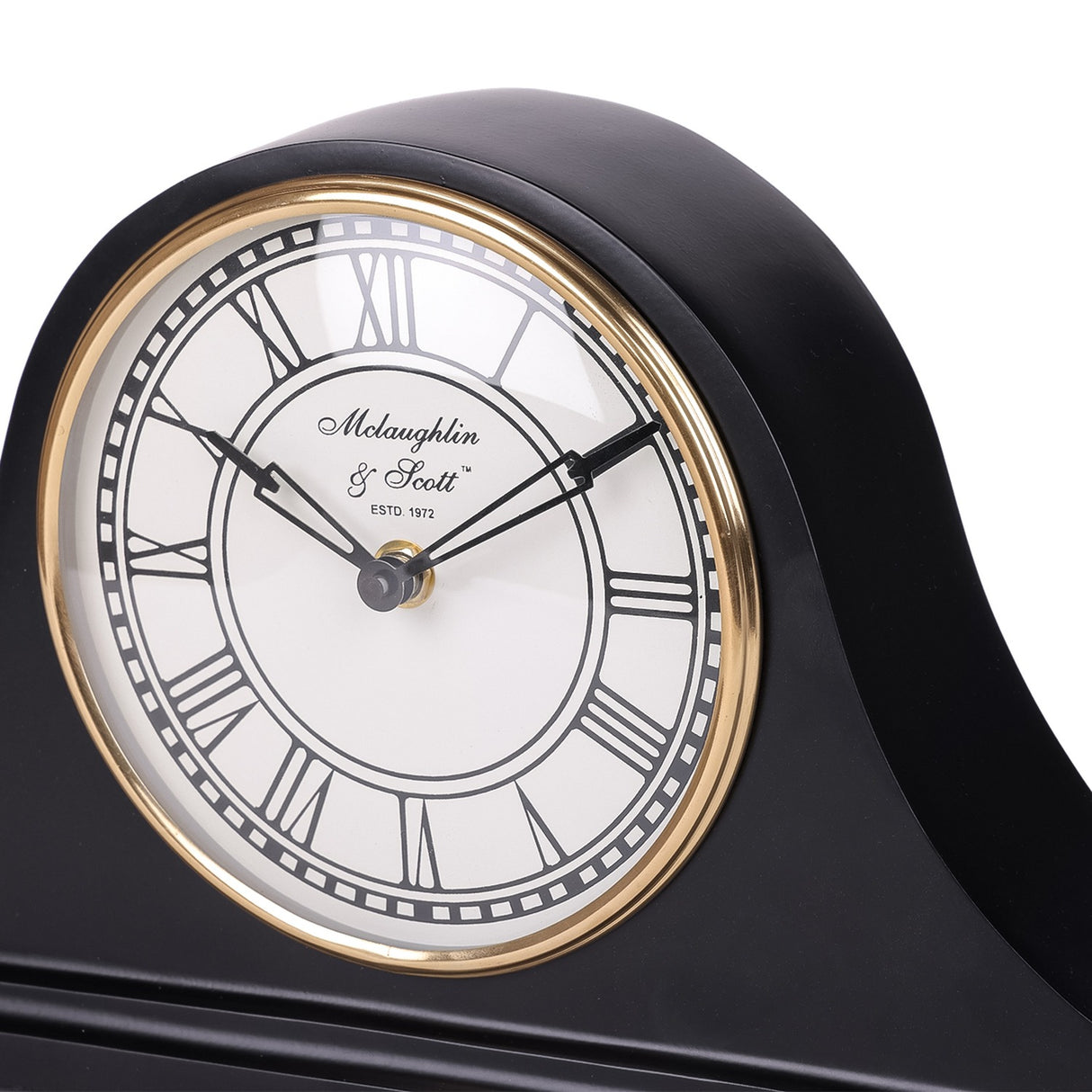 Close-up of the Libra Interiors Matt Black Roman Numeral Mantel Clock showing the white dial, black Roman numerals and antique gold bezel.