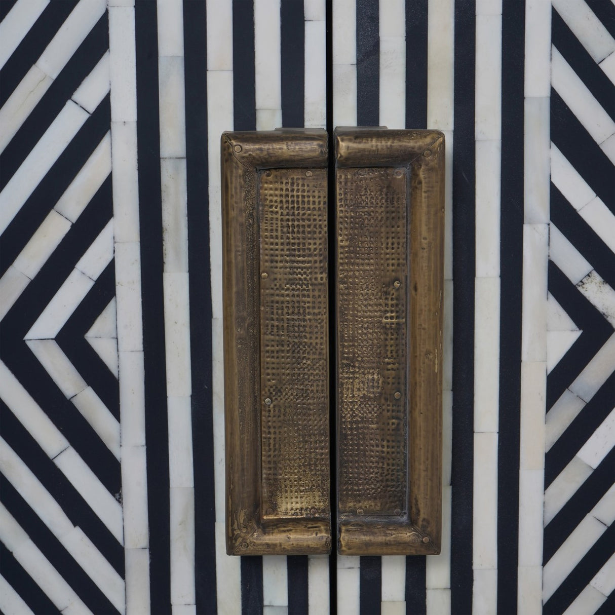 Close-up of Libra Interiors Bone Inlay Sideboard showing black and white geometric inlay pattern and antique brass-finish handles on the central doors.