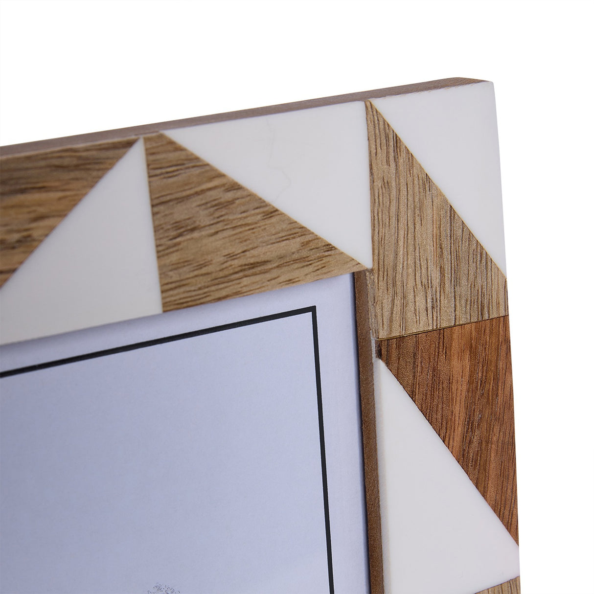 Close-up of Libra Interiors Geometric Wood and Resin Photo Frame corner, showing triangular inlay of cream resin and warm brown wood grain.