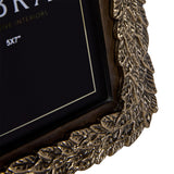 Close-up of the Libra Interiors Antiqued Gold Leaf Photo Frame corner, showing the cast aluminium raised leaf border and dark wooden inner frame.