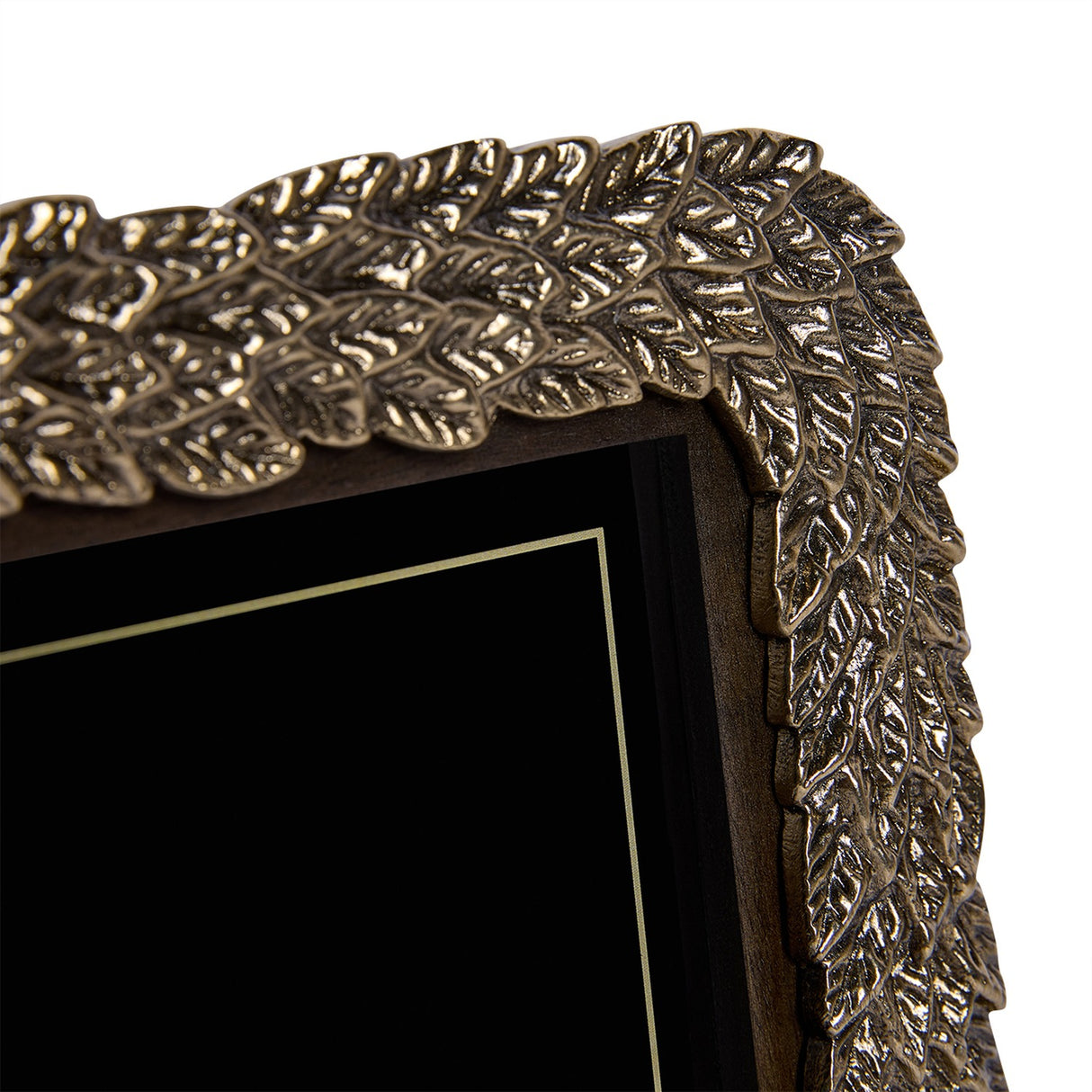 Close-up of the Libra Interiors Antiqued Gold Leaf 4x6 photo frame corner, showing the raised layered leaf motif in cast aluminium with warm gold sheen.