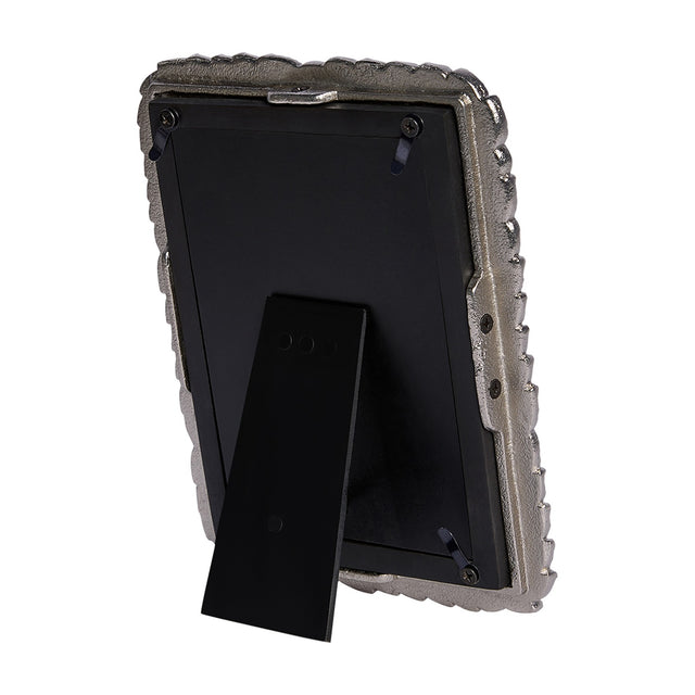 Rear view of the Libra Interiors Antiqued Leaf Aluminium Photo Frame in silver, showing the black backing board, turn tabs, screws and fold-out easel stand.