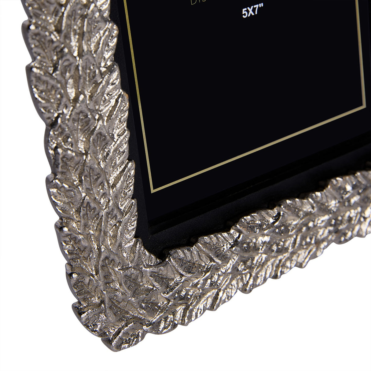 Close-up corner detail of the Libra Interiors Antiqued Leaf Aluminium 5x7 photo frame, showing the raised silver leaf motif and black backing board.