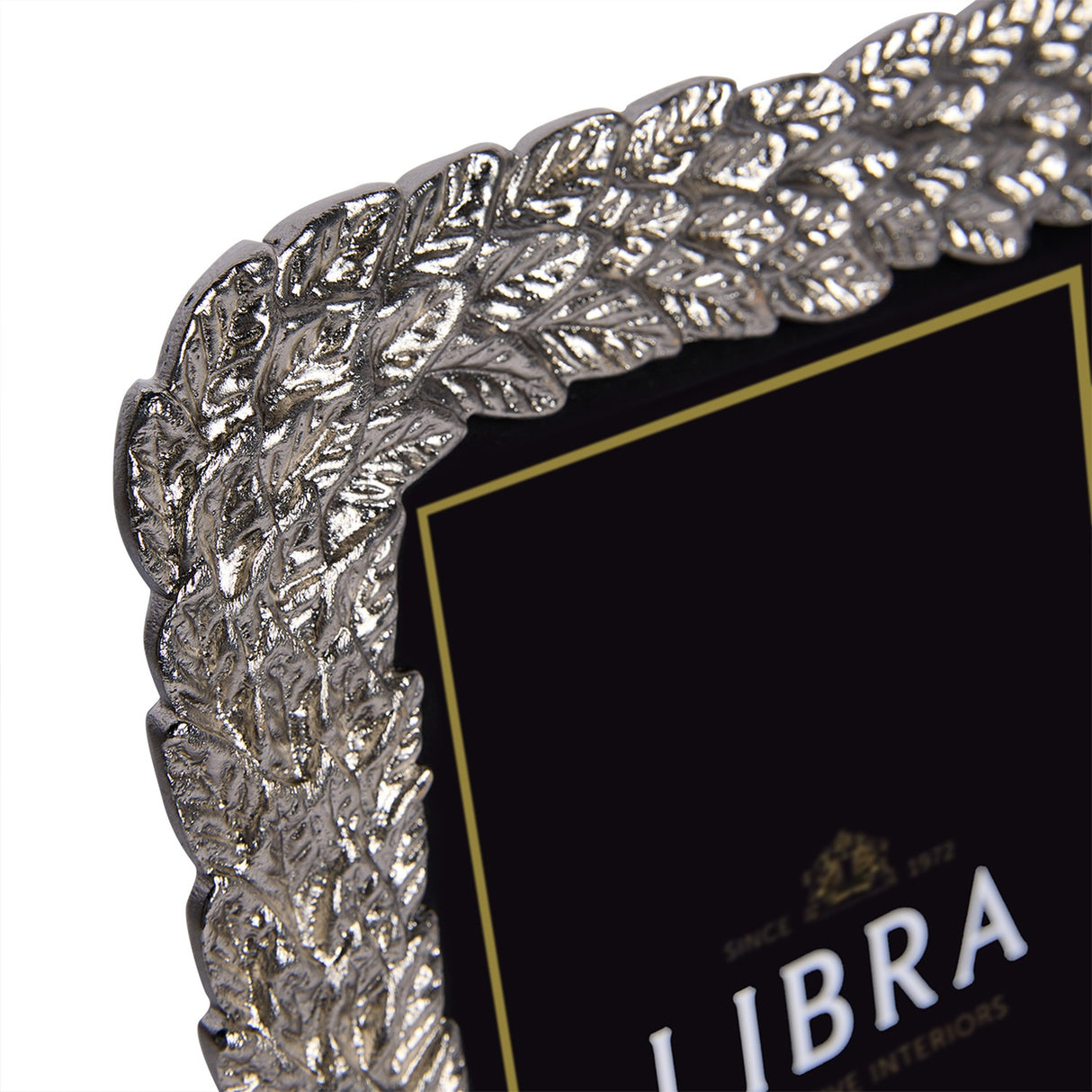 Close-up of the Libra Interiors Antiqued Leaf aluminium photo frame in silver, showing the raised leaf motif border in antiqued pewter finish.