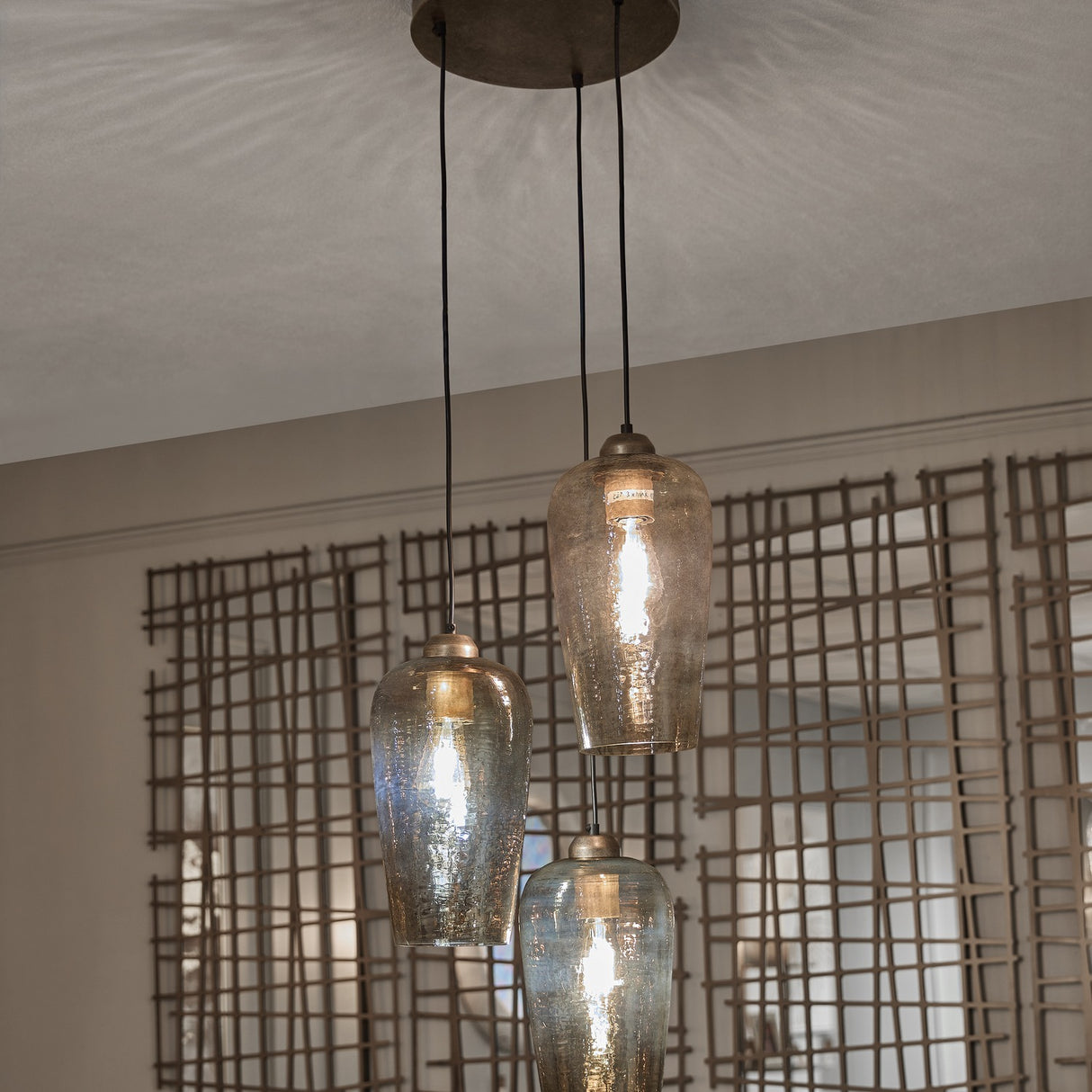 Libra Interiors Hammered Glass 3 Light Drop Chandelier in brown with tulip-shaped lustred glass shades at staggered heights from a champagne gold ceiling rose.