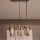 Libra Interiors Hammered Glass 3 Light Linear Chandelier in brown with tulip-shaped lustred glass shades and champagne gold fittings above a panelled wall.
