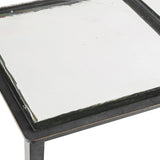 Close-up of the Libra Interiors Textured Glass and Iron Console Table showing the brick-pattern glass top set within a black iron frame.