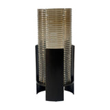 Libra Interiors Ribbed Glass Bronzed Iron Hurricane Lantern in brown, featuring a tall cylindrical ribbed glass shade held within a curved iron frame.