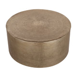 Libra Interiors Drum Storage Coffee Table in champagne gold aluminium with a pitted, textured finish and lift-off lid, on a plain white background.