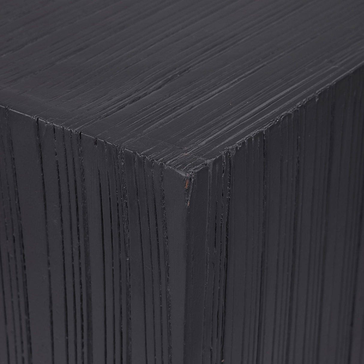 Close-up of Libra Interiors Grooved Wood Black Display Plinth showing the matt black mango wood corner with vertical carved linear grooves.