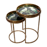 Libra Interiors Removable Tray Top Nesting Side Tables in gold with round antiqued iron frames and tropical bird print trays under glass.