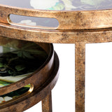 Libra Interiors gold nesting side tables with antiqued iron frames and removable glass-covered tropical bird tray tops featuring cut-out handles.