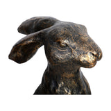 Close-up of Libra Interiors Antique Bronze Sitting Hare Sculpture showing the textured bronze head, long ears and finely sculpted face on a white background.