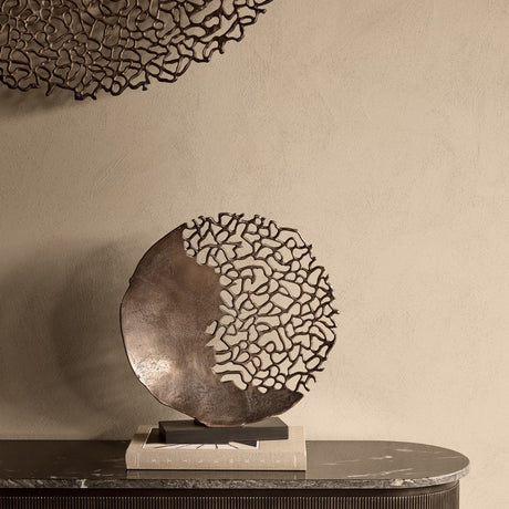 Libra Interiors Coral Cut-Out round aluminium sculpture in bronze on a black base, displayed on books atop a marble sideboard with matching wall art above.