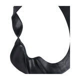 Close-up of the Libra Interiors Looping Abstract sculpture showing the matt black cast aluminium loop with gently textured, twisting curves.