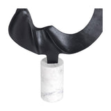 Libra Interiors Looping Abstract sculpture detail showing the matt black cast aluminium loop meeting the smooth cylindrical white marble base.