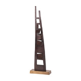 Libra Interiors tall geometric cut-out aluminium sculpture in blackened bronze with angular block details, set on a brass-toned base against a white background.