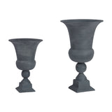 Libra Interiors Stonewash Aluminium Urn Vases in grey, shown in two sizes with flared bowls, ball detail and square plinth bases on a white background.