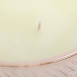 Close-up of Libra Interiors Embossed Glazed Ceramic Bowl Candle in ivory, showing a single wick in pale wax above the glossy embossed geometric rim.