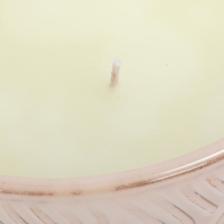 Close-up of Libra Interiors Embossed Glazed Ceramic Bowl Candle in ivory, showing a single wick in pale wax above the glossy embossed geometric rim.