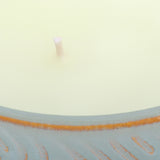 Close-up of the Libra Interiors Embossed Ceramic Bowl Triple-Wick Candle in green, showing pale wax, a central wick and blue-green embossed rim.