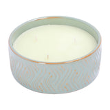 Libra Interiors embossed ceramic triple-wick candle in soft blue-green with gold geometric relief pattern and unscented ivory wax, on a white background.