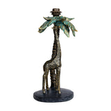 Libra Interiors Giraffe & Palm resin candle holder in gold, with a textured giraffe beneath verdigris-washed palm fronds on an oval base.