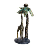 Libra Interiors Giraffe & Palm resin candle holder in aged gold with verdigris-washed palm fronds and textured giraffe on an oval base.