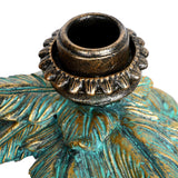 Close-up of the Libra Interiors Giraffe & Palm resin candle holder showing the antique gold taper cup nestled among textured verdigris palm fronds.