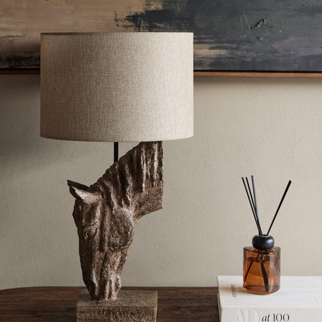 Libra Interiors Sculptural Horse Head resin table lamp in brown with weathered finish and neutral hessian-effect drum shade, styled on a wooden console.