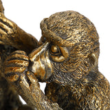 Close-up of the Libra Interiors Textured Antique Gold Three Wise Monkeys resin sculpture, showing the speak no evil figure covering its mouth in detail.