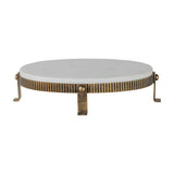 Libra Interiors Marble Oval Aged Gold Cake Stand in white, with a smooth marble top on a corrugated aged gold iron base with splayed feet.