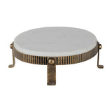 Libra Interiors Marble Oval Aged Gold Cake Stand in white, with a corrugated aged gold iron base, ball detailing and four splayed feet on a white background.