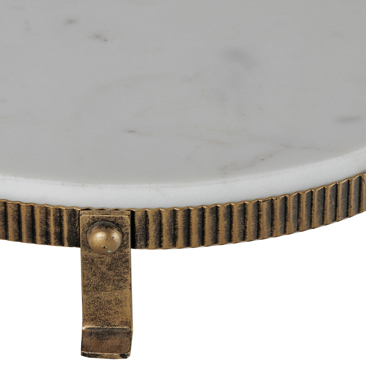 Close-up of the Libra Interiors Marble Oval Aged Gold Cake Stand showing the white marble top, corrugated aged gold iron rim and splayed foot with ball detail.