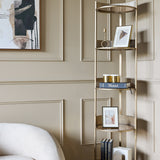 Libra Interiors Ribbed Iron & Marble round wall shelf in gold, styled with framed prints, books and candles in a panelled living room corner.
