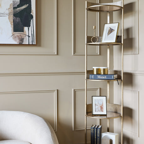 Libra Interiors Ribbed Iron & Marble round wall shelf in gold, styled with framed prints, books and candles in a panelled living room corner.
