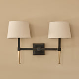 Libra Interiors Twin Linen Shade Bronze Wall Light with dark iron frame, brushed gold tapered arms, square backplate and two bleached linen shades.