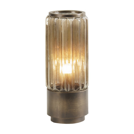 Libra Interiors Fluted Glass Uplighter Table Lamp in brown gold, with a ribbed cylindrical glass shade illuminated over a bronze brushed metal base.