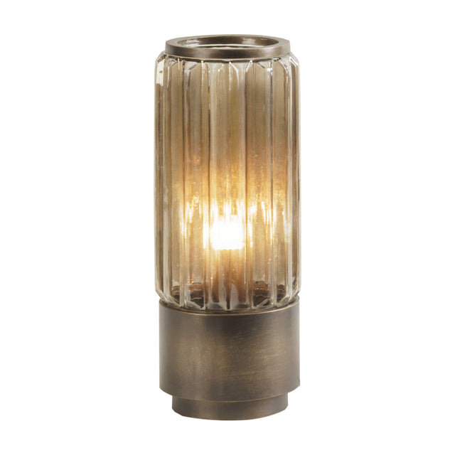 Libra Interiors Fluted Glass Uplighter Table Lamp in brown gold, with a ribbed cylindrical glass shade illuminated over a bronze brushed metal base.