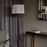 Libra Interiors Bamboo-Effect Ikat Shade Floor Lamp in bronze with pleated grey ikat linen drum shade, styled beside a console table and armchair.