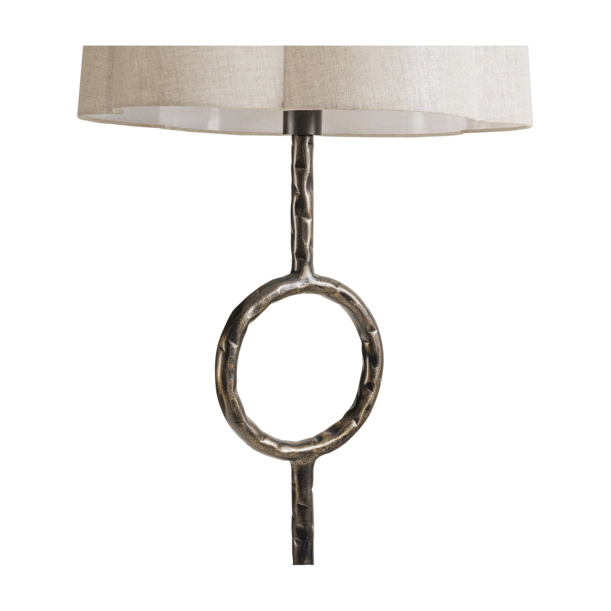 Libra Interiors Hammered Iron floor lamp detail showing the bronze stem with circular open ring motif beneath a scalloped natural linen shade.