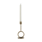 Libra Interiors Ring Iron antique gold candle holder with sculptural ring base, slim upright and cylindrical cup holding a white dinner candle.