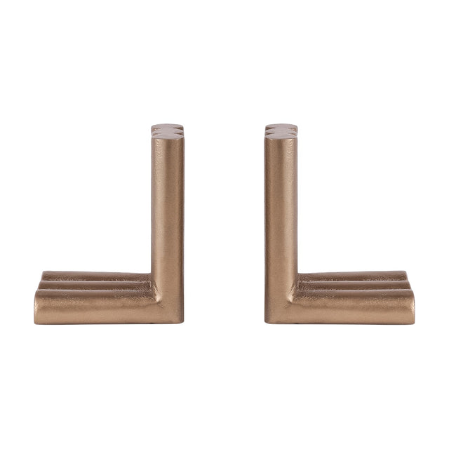 Libra Interiors Ribbed Cast Aluminium Bookends in antique brass, a pair of L-shaped pieces with fluted cylindrical columns, on a plain white background.