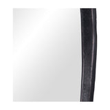 Close-up of the Libra Interiors textured cast aluminium organic wall mirror, showing the curved bronze frame edge against the mirrored glass panel.