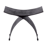 Libra Interiors Cast Aluminium Curved Stool in black, with arched crossed legs and a concave seat in raw textured finish, on a white background.