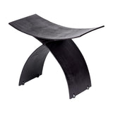 Libra Interiors Cast Aluminium Curved Stool in black, with a concave seat and arched crossed legs in textured cast finish, on a white background.