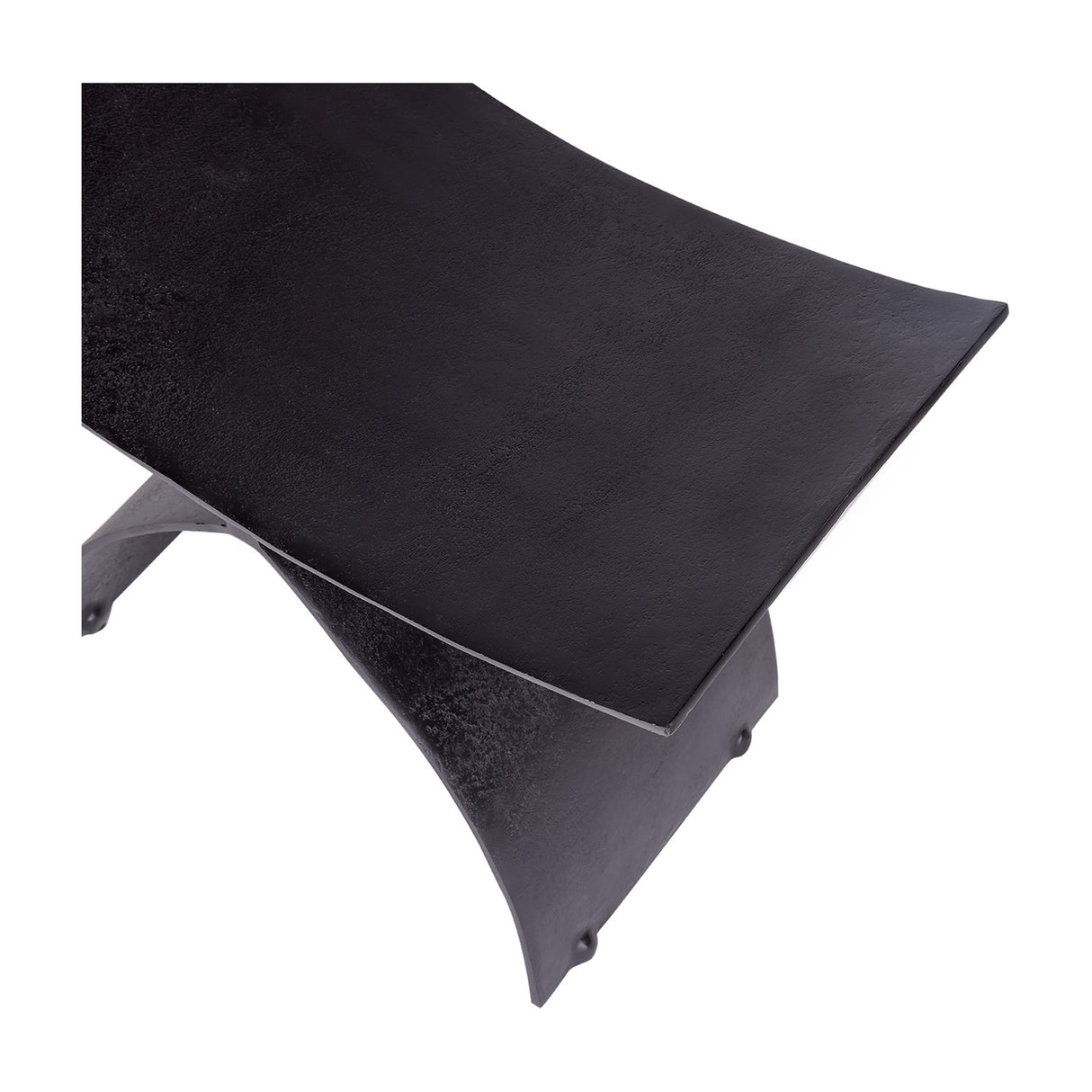 Close-up of Libra Interiors Cast Aluminium Curved Stool in black, showing the concave seat and arched leg with raw textured charred finish.